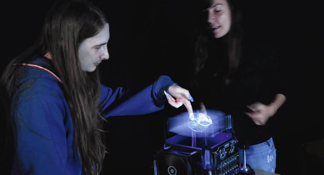 Due persone che osservano un cranio 3D. Uno di questi sta toccando il buco dell'occhio.