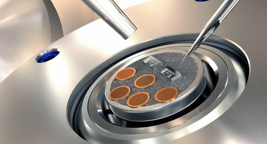 Vista ravvicinata della parte superiore della scatola di trasferimento del campione (sportello superiore aperto), che mostra che il dendrite di litio è stato trasferito utilizzando una punta di micromanipolatore (un ago d'argento affilato) dalle griglie di microscopia elettronica a trasmissione in rame marrone ai dispositivi micromeccanici Rice (blocchi d'argento), pronti per i successivi test e caratterizzazione.