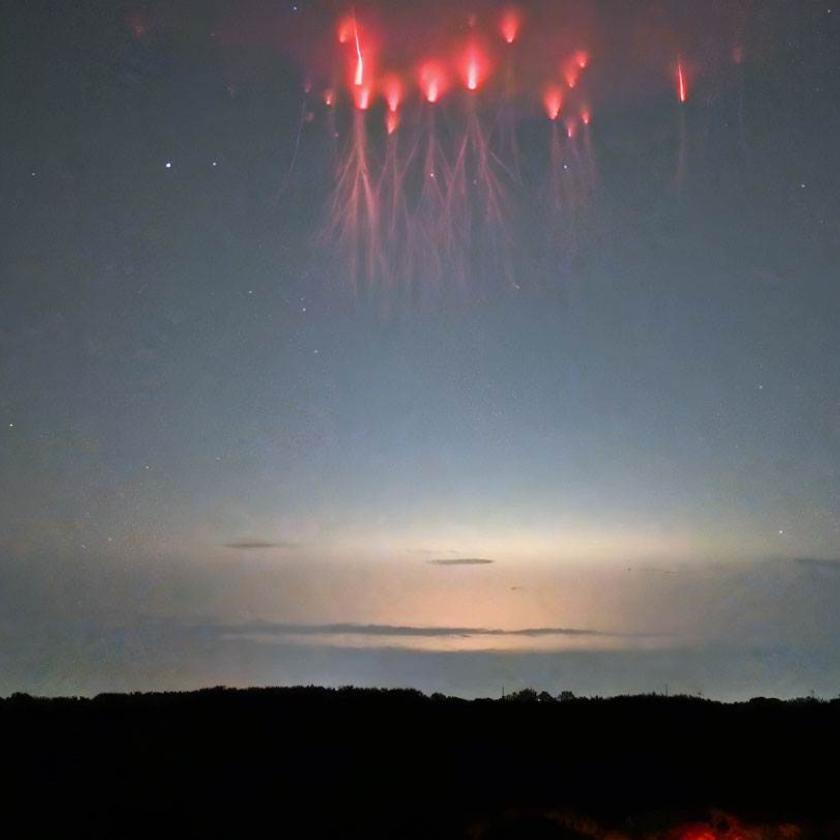 Spettri rossi a forma di medusa si librano sopra una nube temporalesca incandescente.